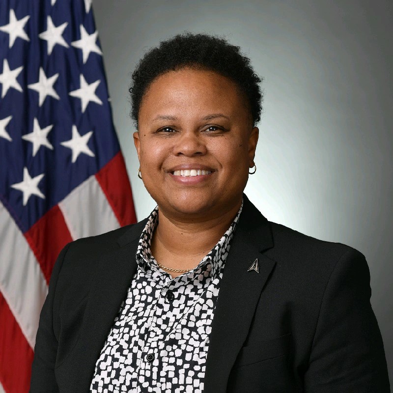 Shawnte Craig smiles in front of an American flag